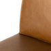 Close-up of tan leather-look counter stool seat corner with stitched edge