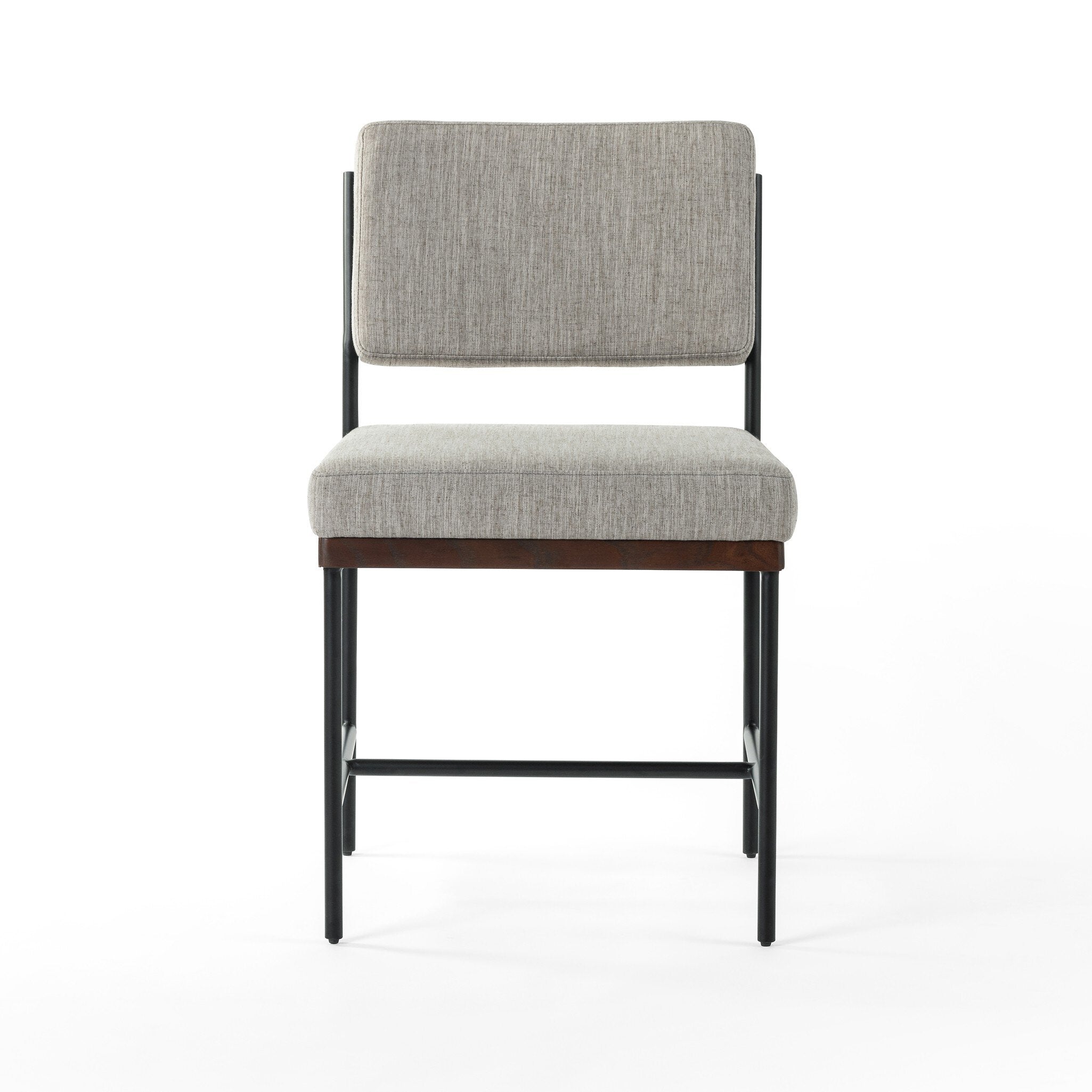 Gray upholstered chair with wooden legs on a white background. Benton Dining Chair in Savile Flannel performance fabric featuring a slim iron frame and wood bar.