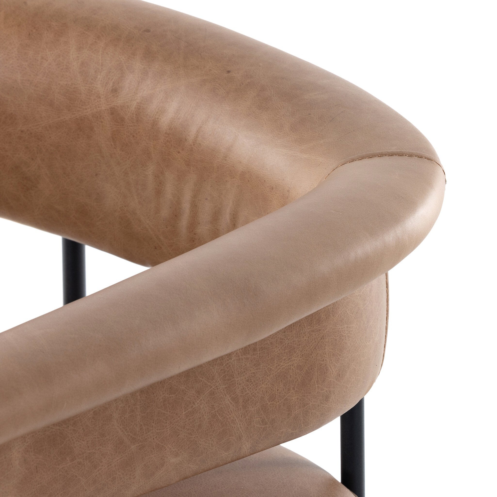 Close-up of tan padded stool armrests and seat edges with black metal legs