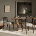 Armless dining chair with dark upholstery, upholstered back, and wooden tapered legs