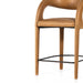 Counter stool detail view of tan padded seat and underside, with wood legs and black footrest bar.