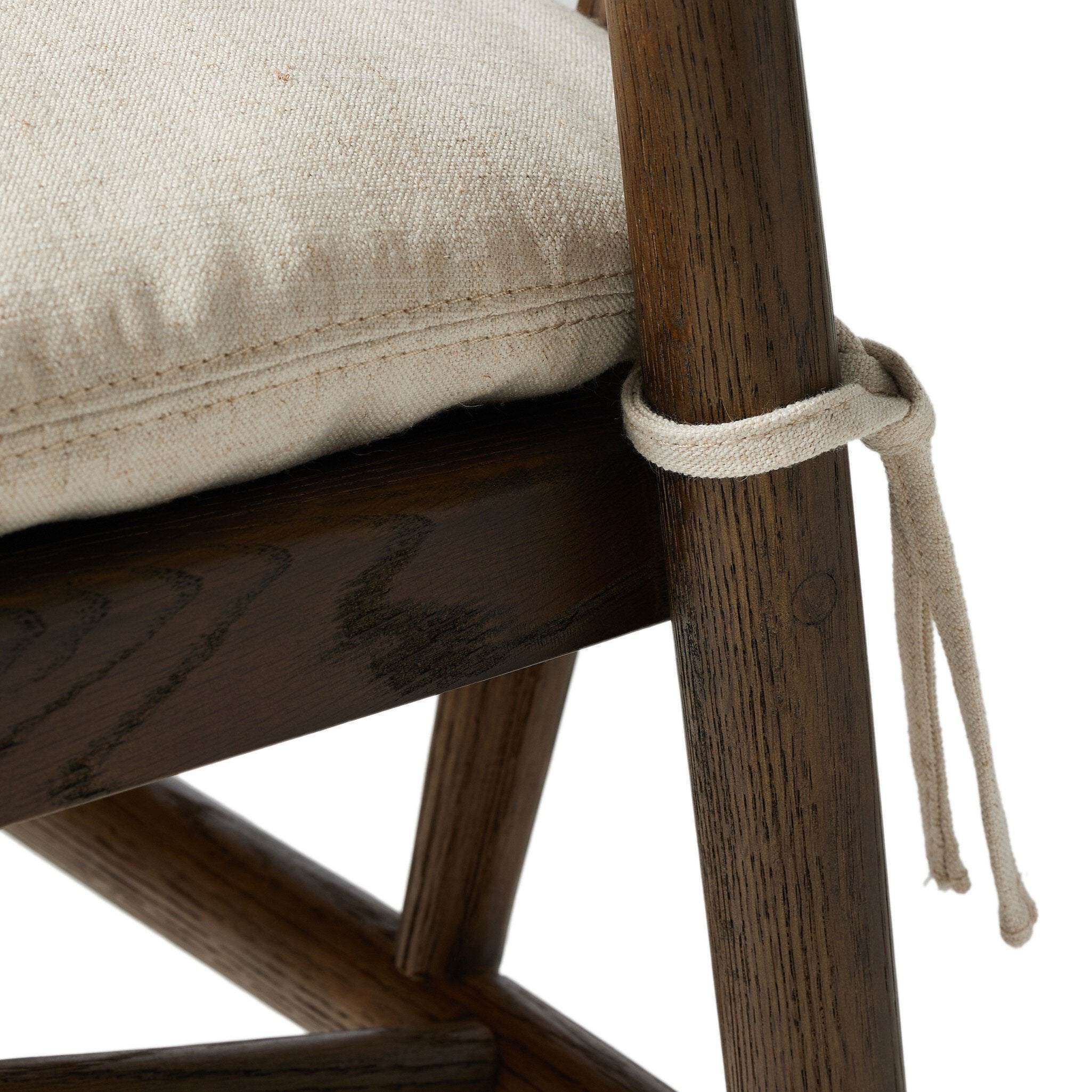 Close-up of a wooden chair with a beige cushion and a rope tie, on a white background.
