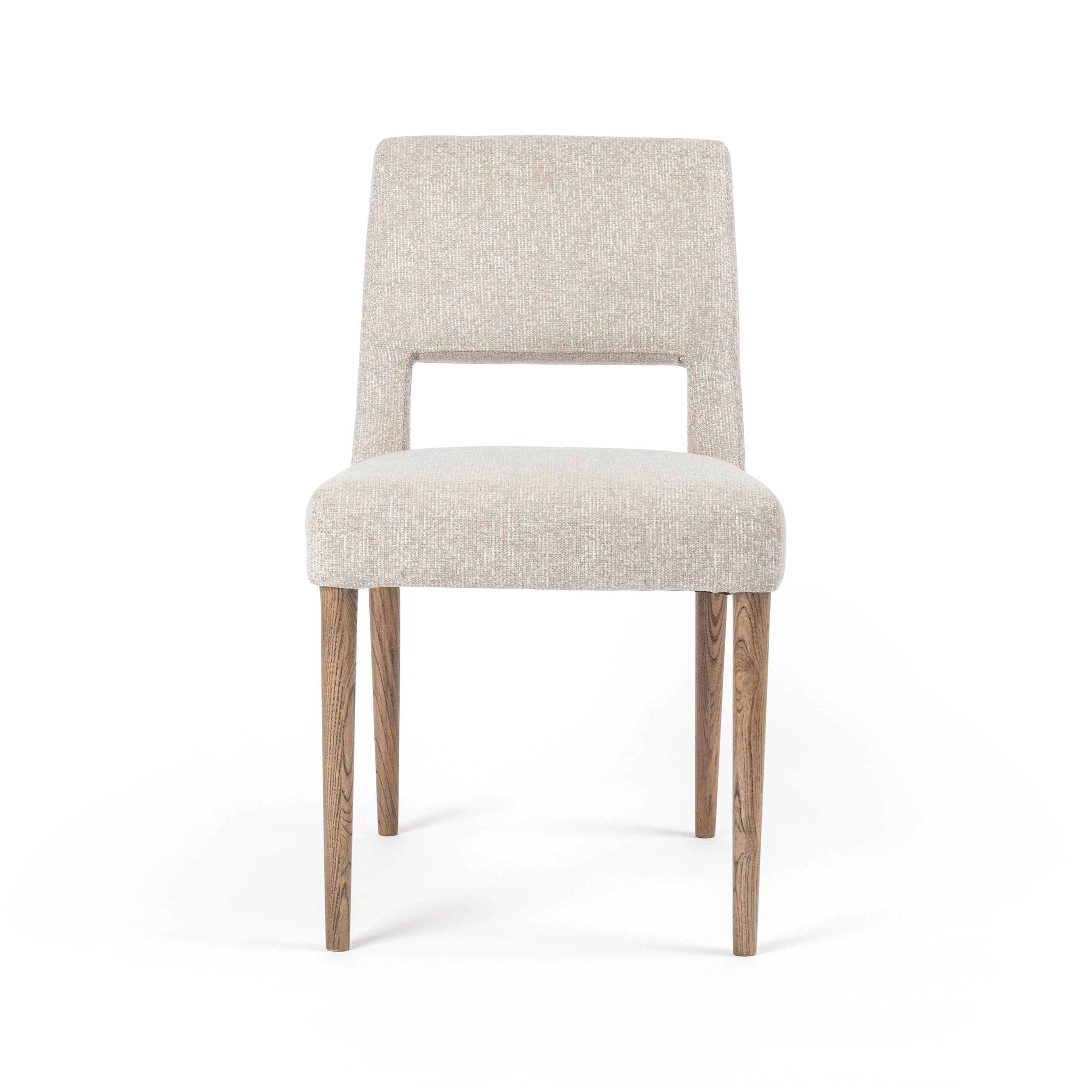 Armless dining chair with light camel upholstered seat and back, and wooden legs.