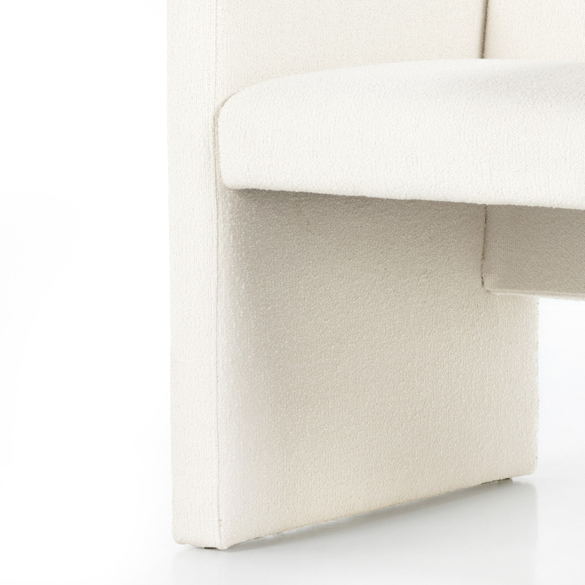 Close-up of a white upholstered chair with a textured fabric finish on a white background