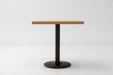 White oak table top with black pedestal base, centered front view