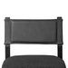 Armless dining chair with dark upholstered back and gray fabric seat cushion, close-up