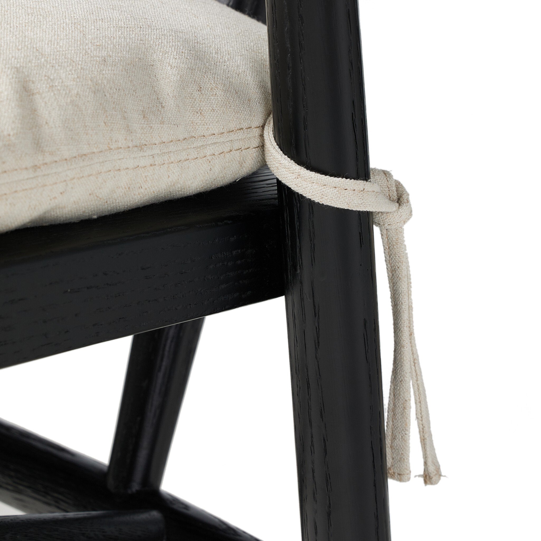 Bar stool with light upholstered seat edge and black wooden leg with tied trim