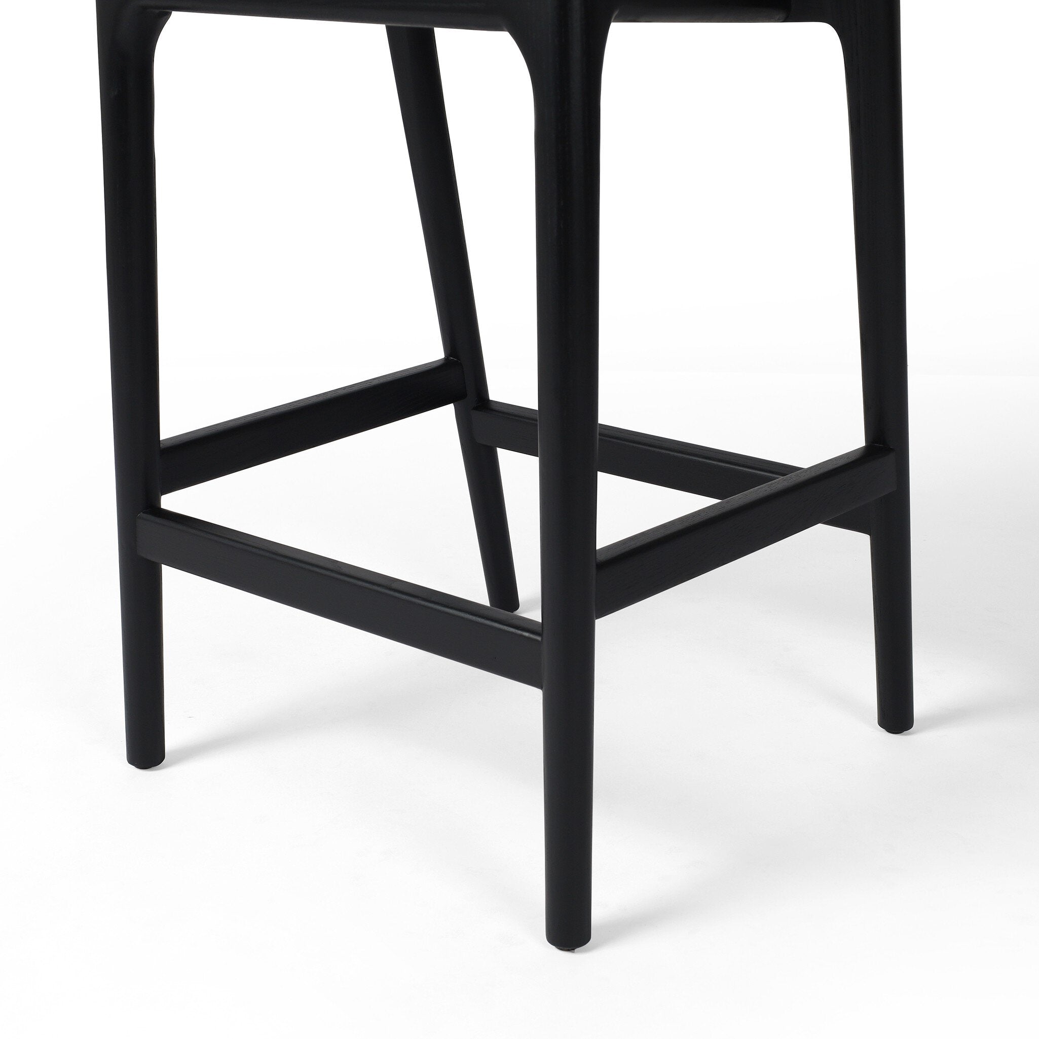 Leg detail Amare Counter Stool with monochromatic top-grain black leather seat and minimalist black-finished Scandinavian solid ash wood base