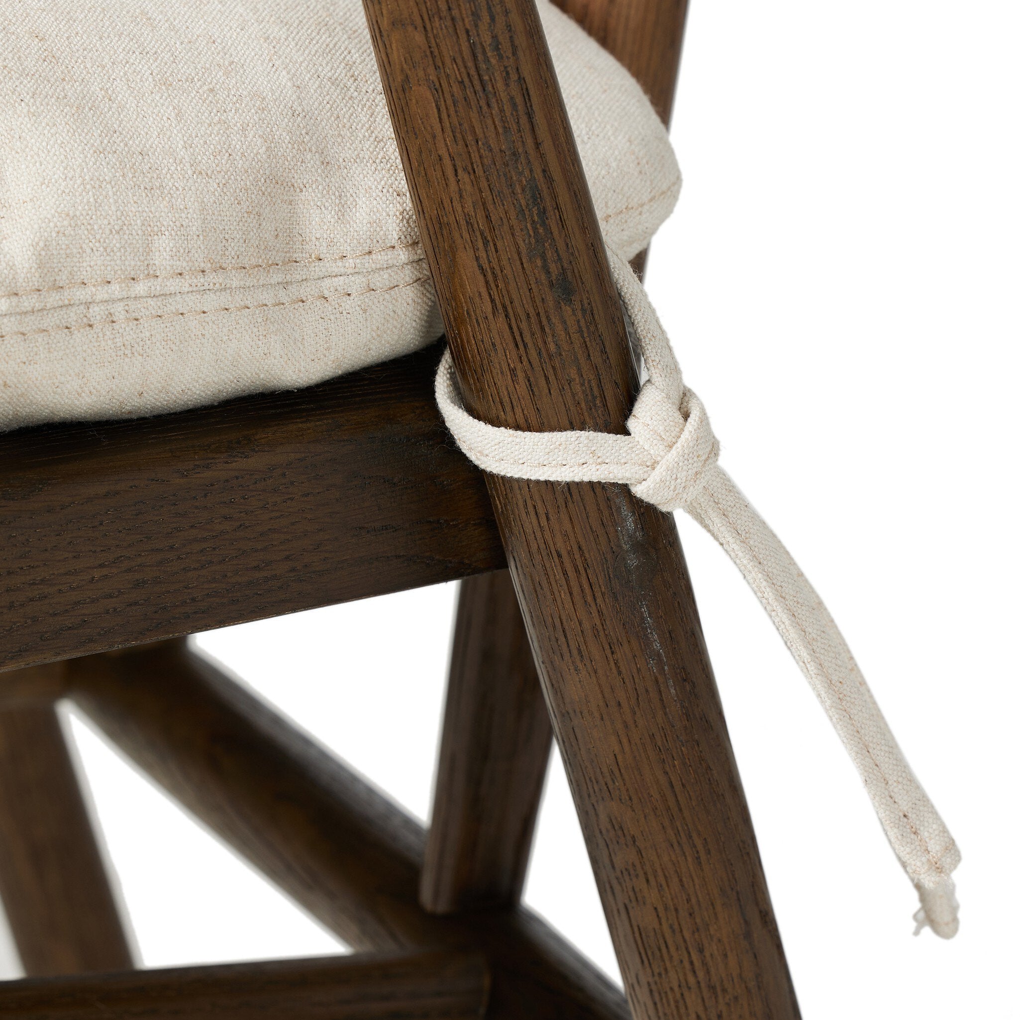 Close-up of a wooden chair with a beige cushion and white rope tie, on a white background.