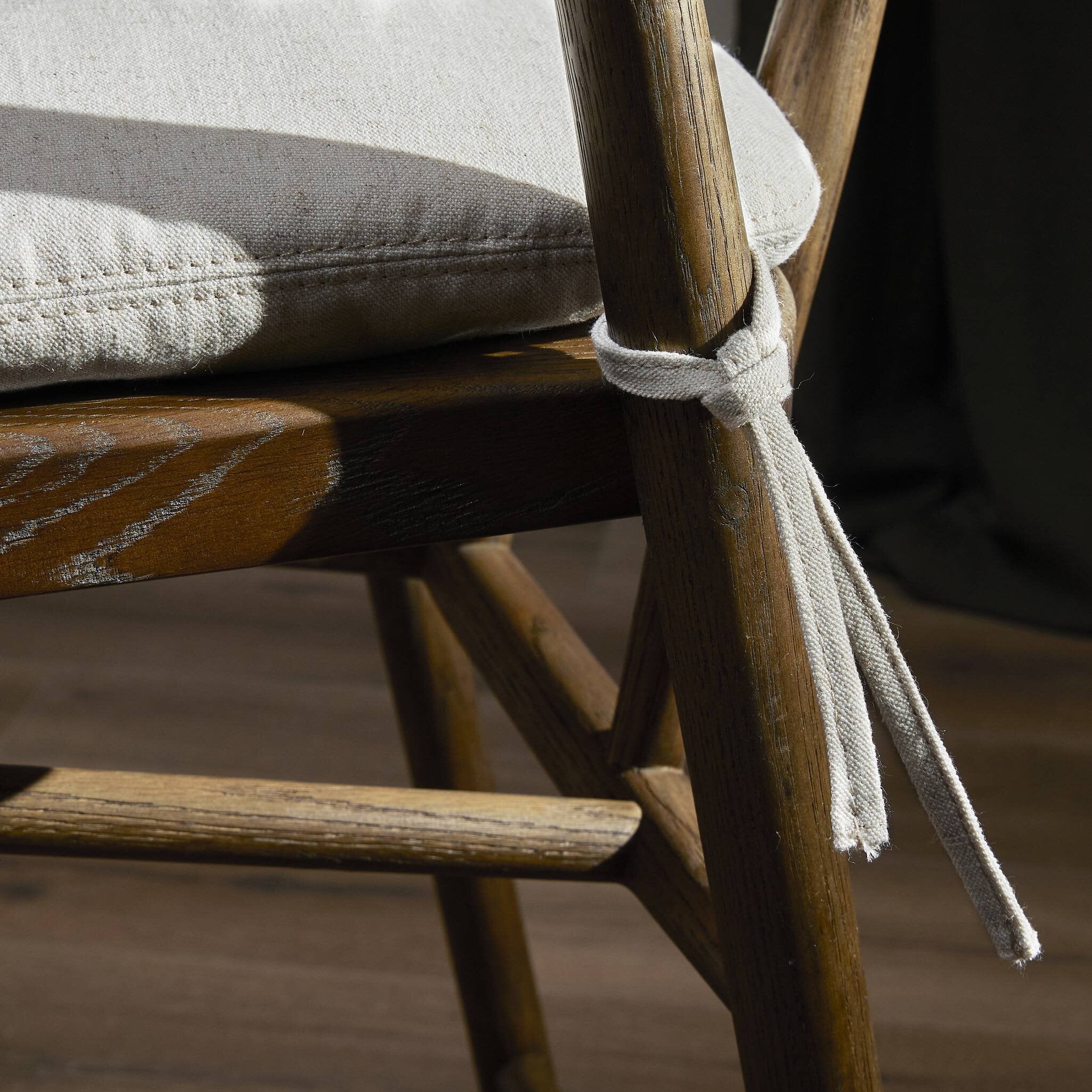 Cream cushion tied to brown wooden bar stool frame