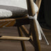 Cream cushion tied to brown wooden bar stool frame