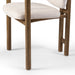 Leg detailing Madeira three-legged dining chair featuring a tubular frame and a curved barrel backrest in cream upholstery