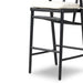 Black wood bar stool with light cushion seat and woven back panel