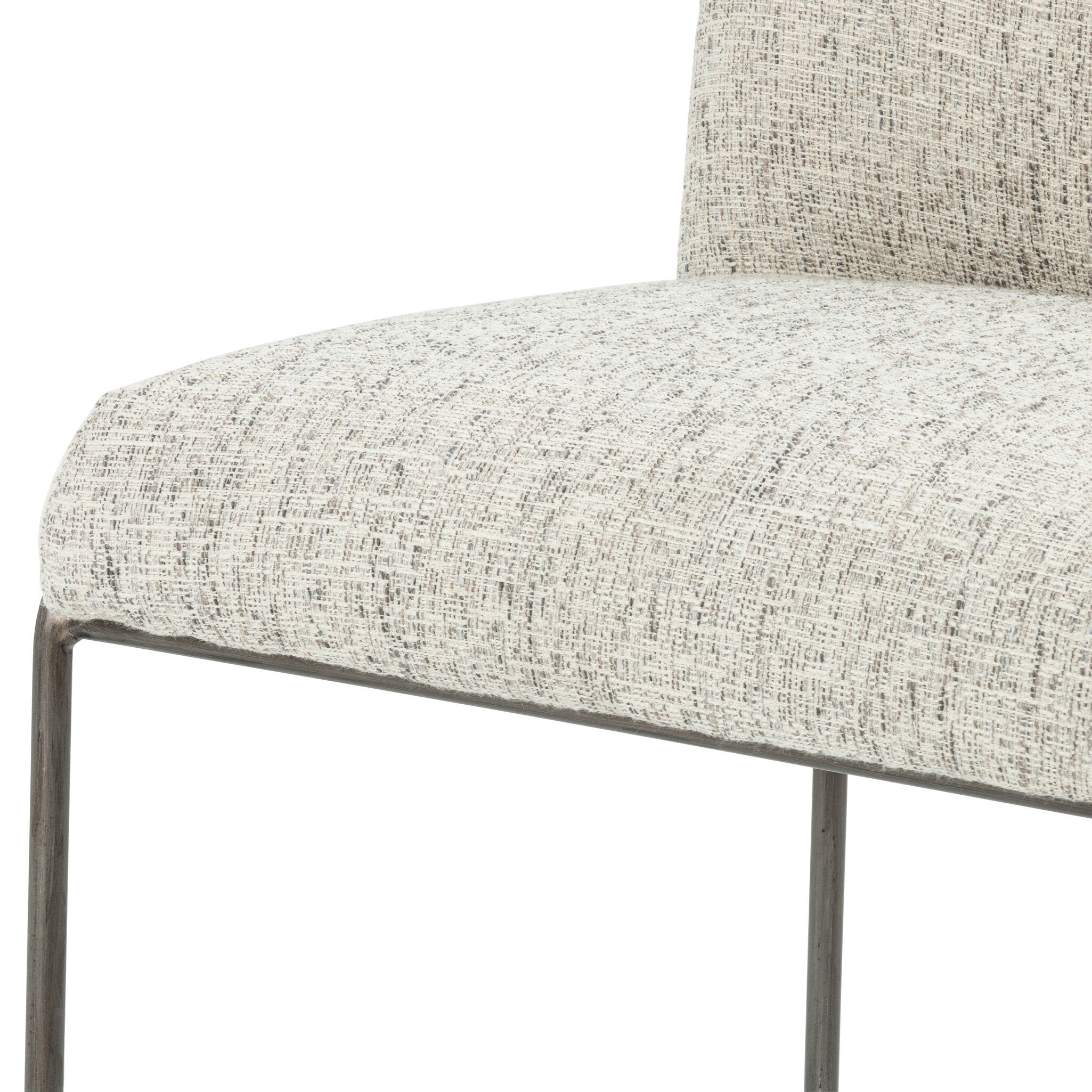 Light gray upholstered bar stool seat edge with dark metal arm and frame