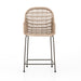 Modern low-armed outdoor dining chair with white wicker weaving and a bronze industrial frame for hospitality