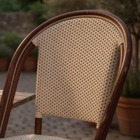 Side chair back with cream woven cane panel and arched dark wood frame.