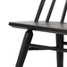 Close-up of dark wood chair arm-free seat edge and supporting stretcher, textured grain