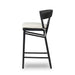 Bar stool side view with black frame, rounded back, and cream padded seat
