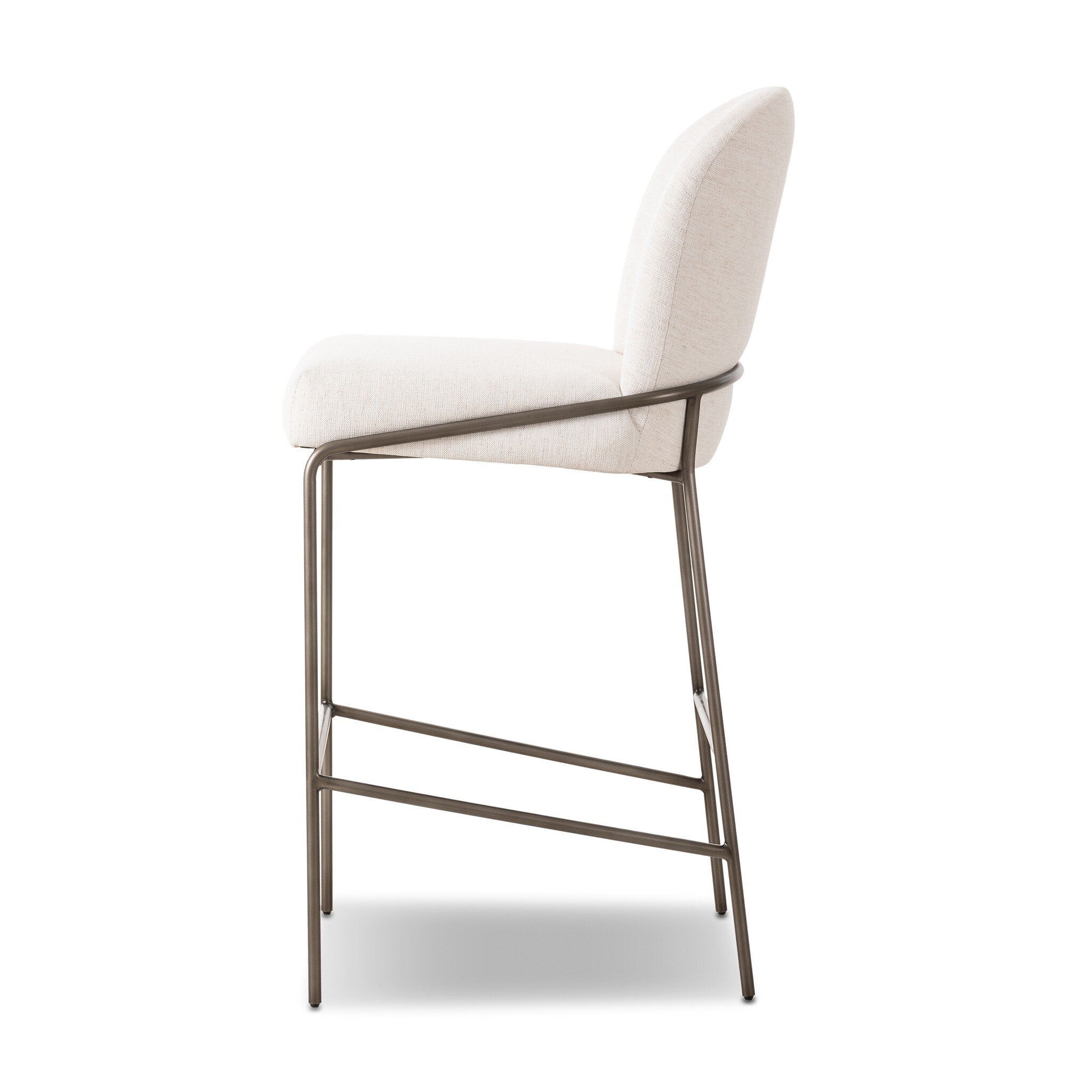 Light fabric bar stool from side; curved backrest, padded seat, and horizontal footrest bar