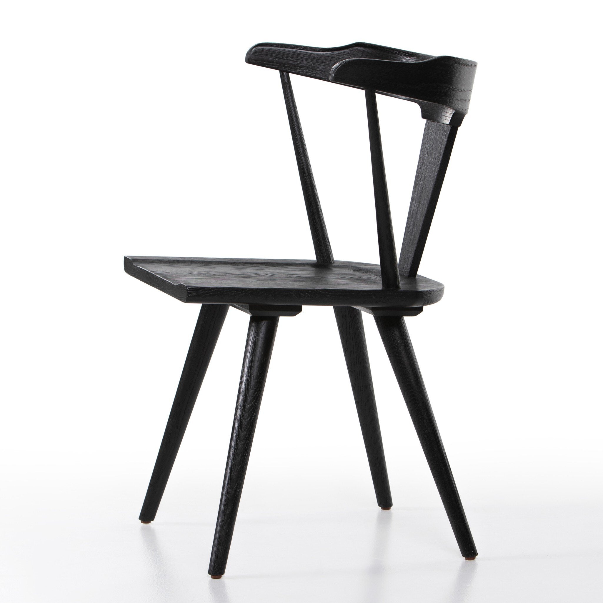 Black wooden chair on a white background. Side Ripley Dining Chair in Black Oak with mid-century Windsor-style sculptural silhouette.