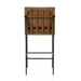 Crete bar stool rear view with tan upholstery and black base with footrest