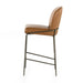 Brown bar stool with low back cushion, padded seat, and black metal crossbar base.