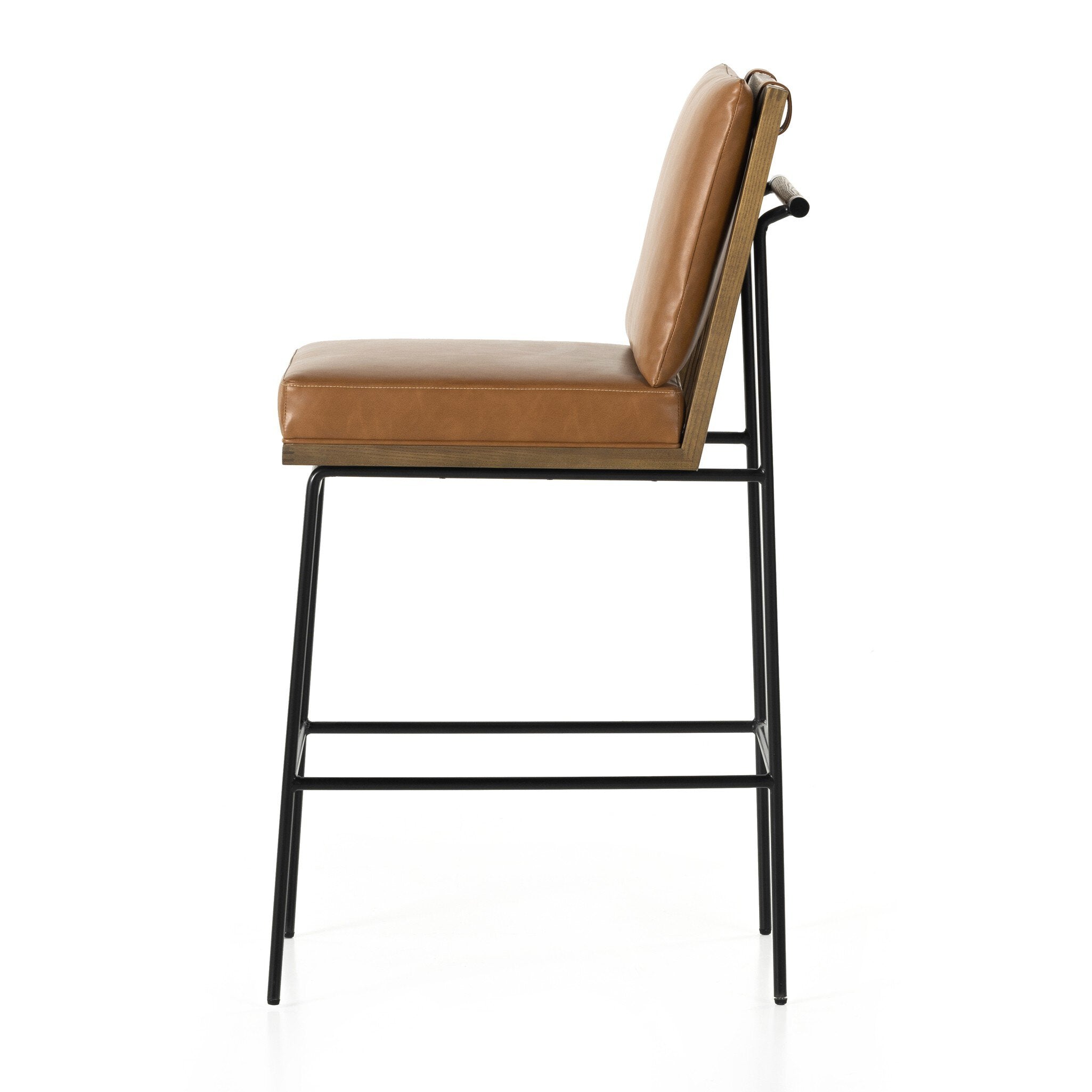 Crete bar stool side view with tan upholstery, black metal footrest, wood arms