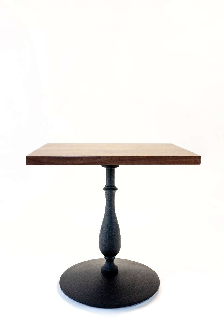 Small table with wooden top and black metal base on a white background