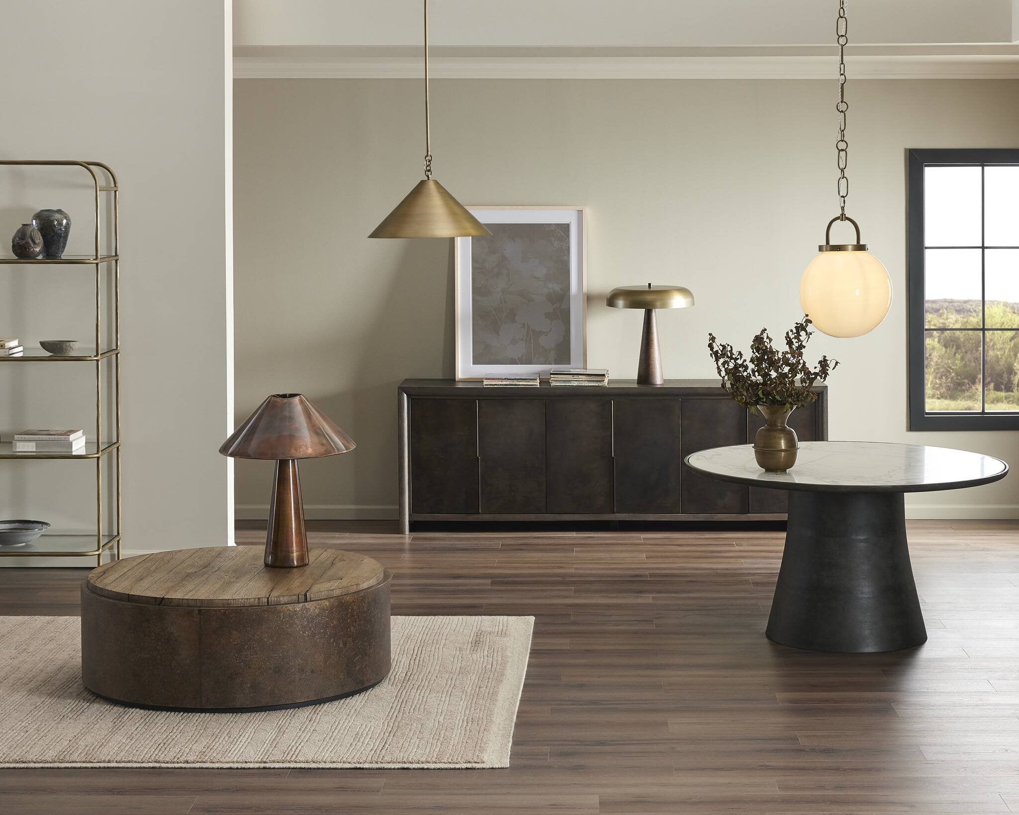 Modern living room with wooden coffee table, round side table, and pendant lights Evelie soft modern pendant light with hand-blown white glass globe and antique brass fixture chain for dining room or entryway on a white background