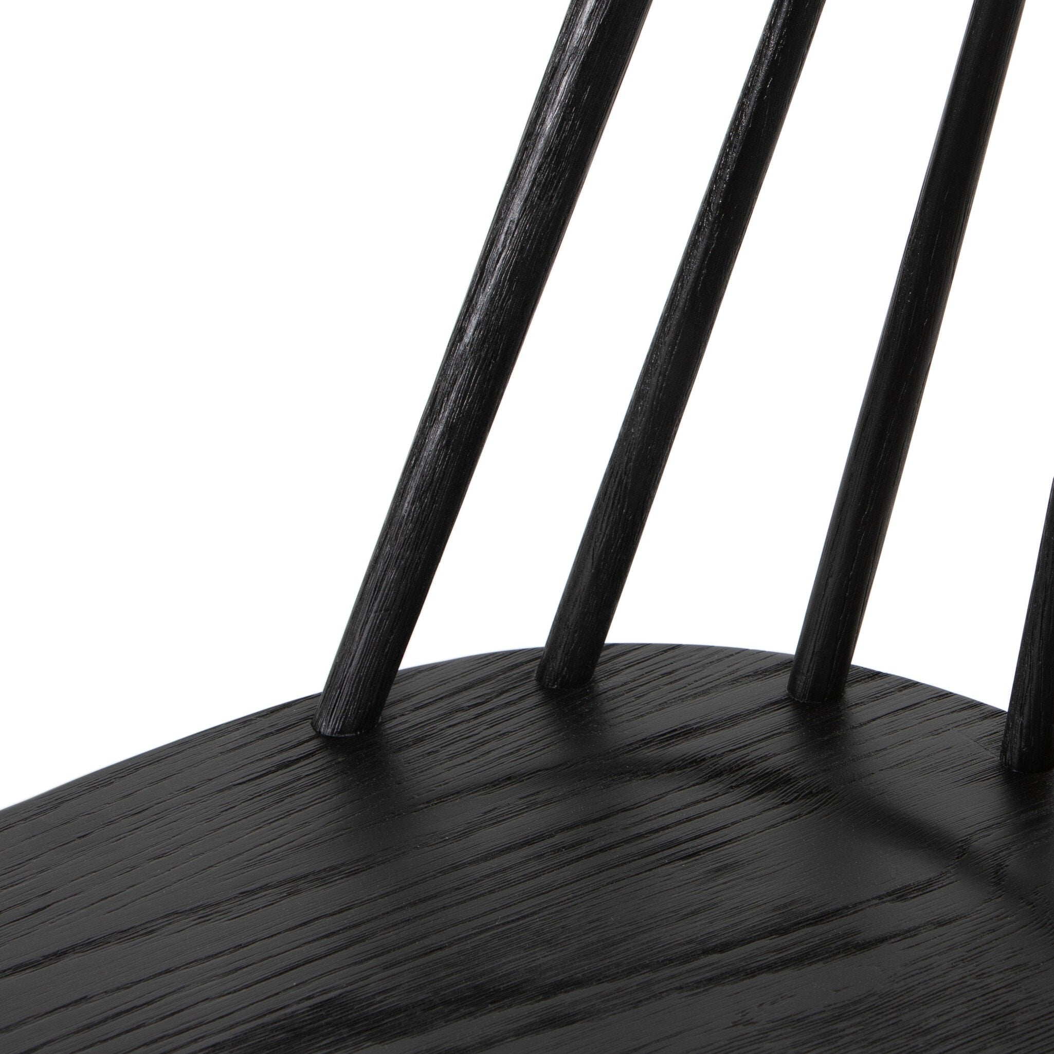 Close-up of dark wood chair seat with slat bases and vertical back supports, black finish