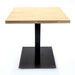 Metal table base with black pedestal column and square base plate under a light wood top