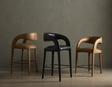 Three bar stools in brown, black, and another brown color against a gray background.