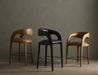 Set of counter stools with curved armrests, upholstered seats, and black metal footrests.