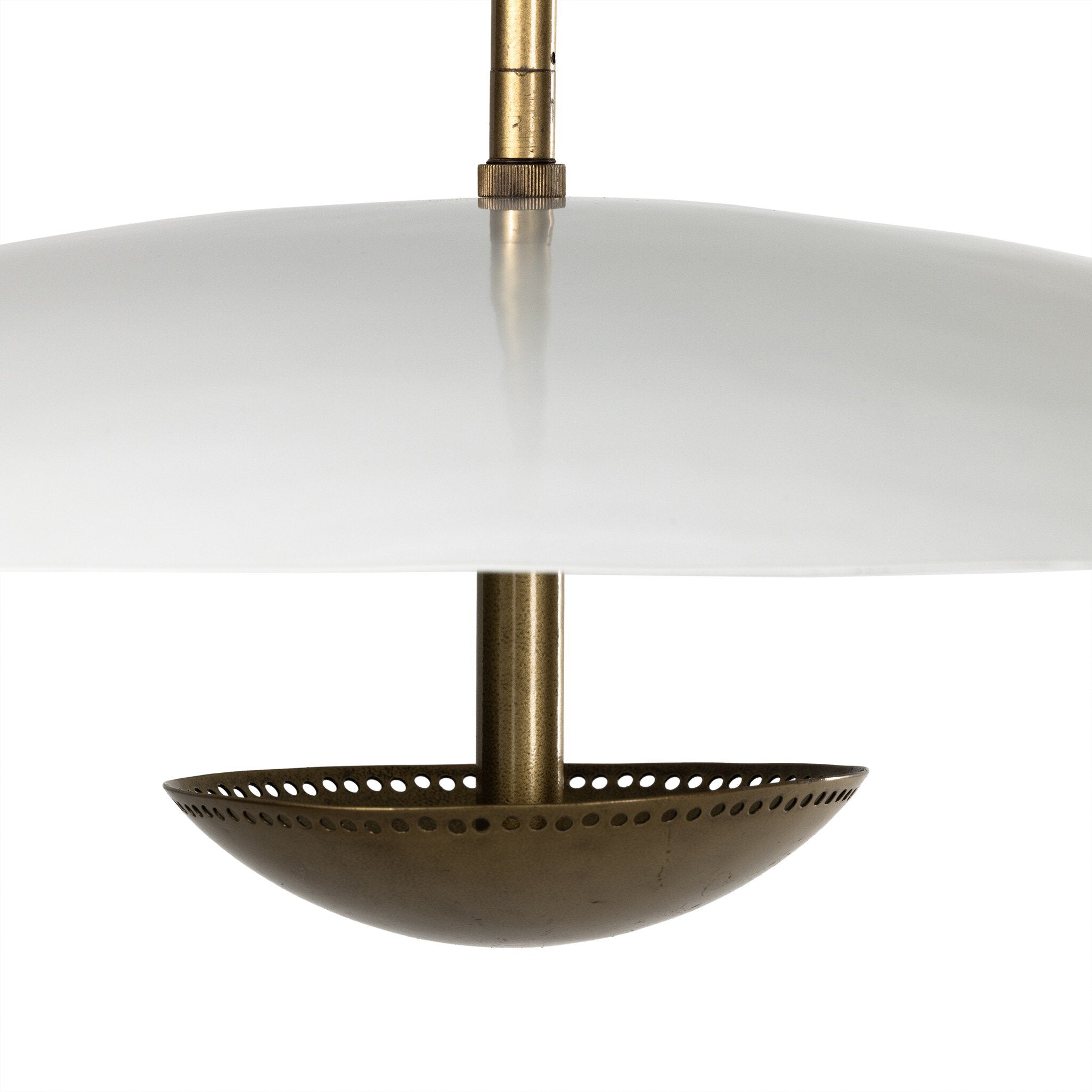 Close-up of a pendant light with brass fixture and white shade on a white background