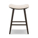 Backless natural linen counter stool with dark wood legs and lower footrest bar