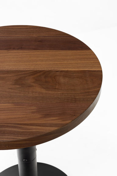 Walnut table top with smooth dark-brown finish and rounded edge detail.