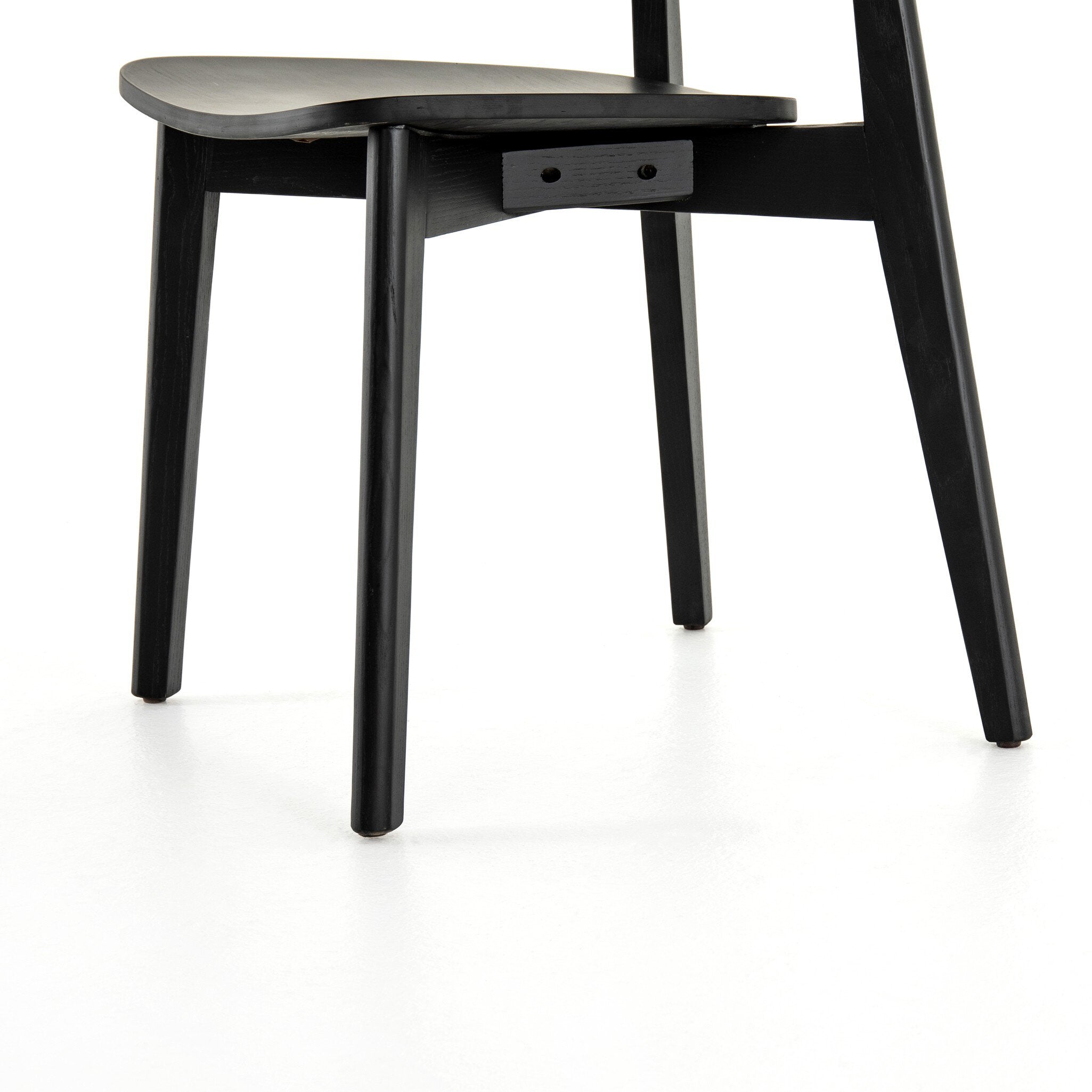 Black armless dining chair showing rounded seat, backrest, and four angled legs.