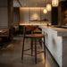 Bar stool with tan leather-look seat and back, dark wood frame and footrest
