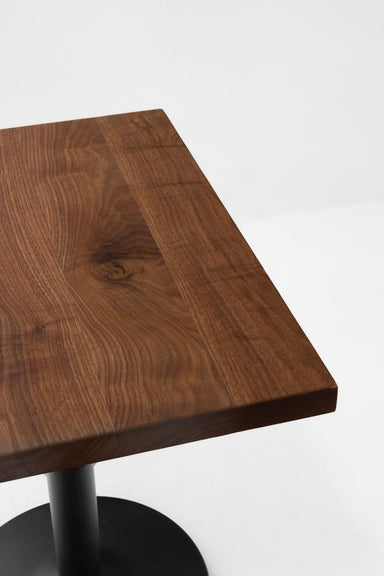 Rustic walnut table top with visible grain and warm brown finish, beveled edge