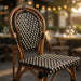 Side chair with curved wood back and black seat, woven cream lattice pattern.