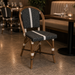 Side chair with black woven seat and back, light wood frame, white striping.