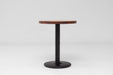 Round walnut table top with dark-brown finish mounted on a black pedestal base.