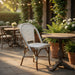 Nautilus side chair with white-gray woven seat and back, curved arms, wood legs