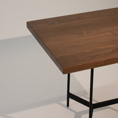 Wooden table with black metal legs on a light gray background