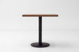 Square walnut tabletop on black pedestal base, dark stained finish