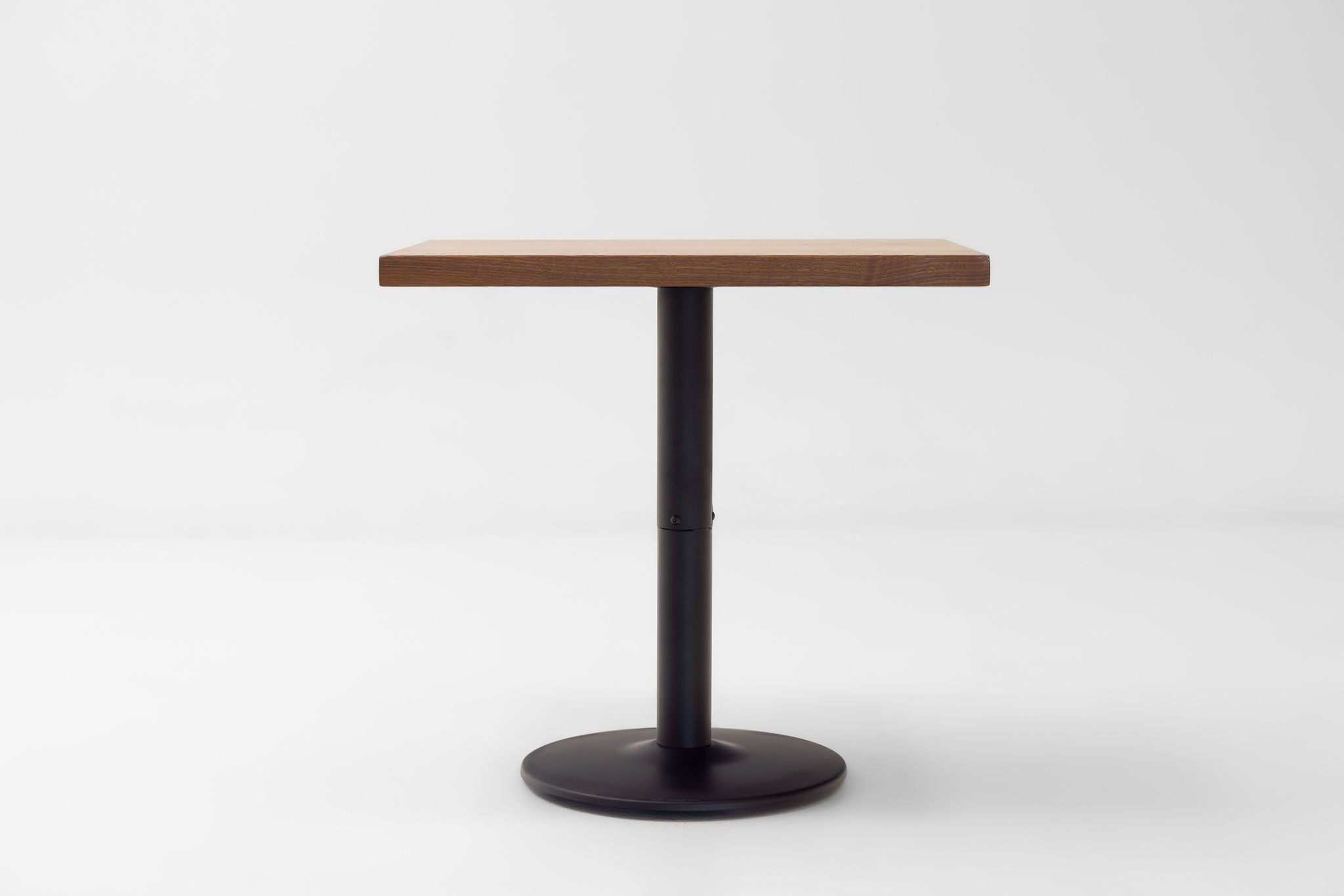 Square walnut tabletop on black pedestal base, dark stained finish