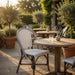 Outdoor side chair with white-and-blue woven seat, arched back, and wooden frame