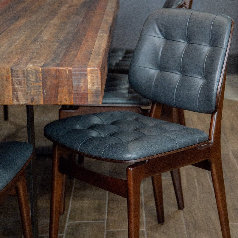 Sutton side chair with dark blue button-tufted upholstery and warm wood frame