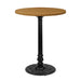 Black cast table base with round decorative foot supporting a light wood tabletop