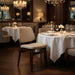 Upholstered side chair with light beige seat and back, dark wood frame in a dining setup